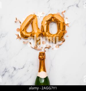 Bottiglia di Champagne con numero gold 40 palloncino. La minima parte anniversario concetto Foto Stock