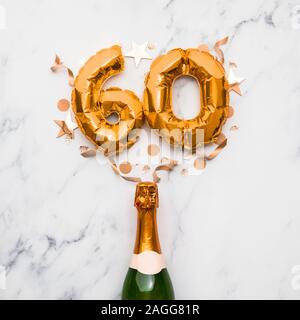 Bottiglia di Champagne con numero gold 60 palloncino. La minima parte anniversario concetto Foto Stock