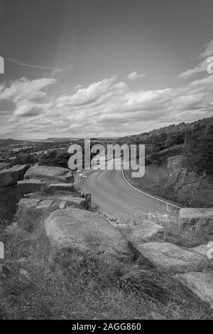 Un avvolgimento serpeggiante strada che scorre attraverso il Parco Nazionale di Peak District nel Derbyshire, la splendida campagna inglese, REGNO UNITO Foto Stock