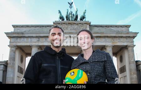 19 dicembre 2019, Berlin: Pallavolo: conferenza stampa del Parlamento Pallavolo Associazione CEV presso l'Hotel Adlon con rappresentanti di DVV VBL, BR Volleys e l'amministrazione del Senato per gli affari interni e Sport. Benjamin Patch (l), player BR Volleys e Christiane Fürst, tre volte vincitore della Champions League, sono in piedi di fronte alla Porta di Brandeburgo con le sfere di pallavolo. La pallavolo europea Association (CEV), il tedesco della pallavolo Association (DVV), la Pallavolo Bundesliga (VBL), la città di Berlino e Berlino Volleys riciclaggio continueranno la loro stretta cooperazione nel 2020. Ph Foto Stock