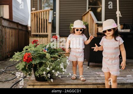 Sorelle scendendo le scale in cortile Foto Stock