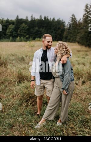 Coppia giovane costeggiata e parlando in campagna Foto Stock