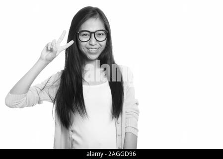 Studio shot di giovani asiatici felice ragazza sorridente e dando segno di pace Foto Stock