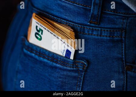 Banconote da vicino il denaro in una tasca dei jeans. EURO stick fuori dalla tasca dei jeans, finanza e concetto di valuta. Concetto di risparmio o di spendere del denaro Foto Stock