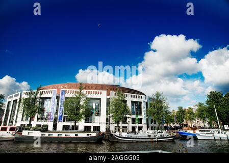 Canale di Amsterdam ed edifici. La Stopera complesso edificio sede del municipio di Amsterdam e della nazionale olandese per Opera e Balletto Foto Stock