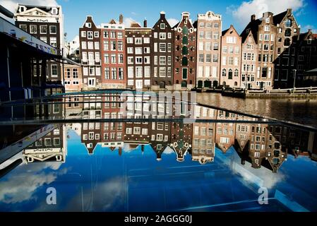 Canale di Amsterdam ed edifici. Fila di tradizionali case di Amsterdam prese da imbarcazione turistica con riflessioni di case che mostra nel tetto di vetro della barca Foto Stock