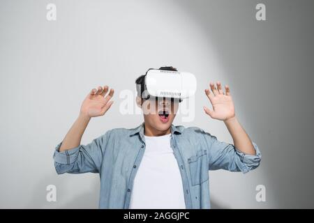 Uomo felice prendere l'esperienza utilizzando cuffie VR bicchieri di realtà virtuale, isolati su sfondo bianco Foto Stock