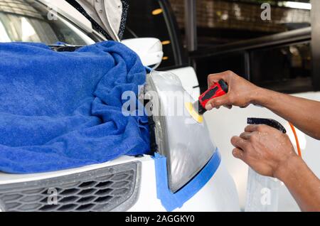 Mechanic la mano di lucidatura è la vettura del faro. Foto Stock