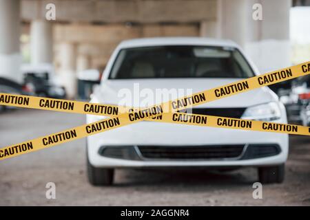 Nessuna colpa consentito qui. Spia gialla di attenzione nastro in prossimità del parcheggio auto al giorno. Scena del crimine Foto Stock