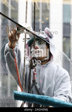 Tokyo, Giappone. Xix Dec, 2019. Un detergente per vetri vestito come un mouse salviette le finestre dell'Hotel Ryumeikan Tokyo. Questo è un evento annuale in cui window cleaners vestire come zodiaco cinese di animali della presente e il prossimo anno per promuovere di fine anno e il nuovo anno. Il 2019 è l'anno del cinghiale, e il 2020 sarà l'anno del ratto. Credito: Rodrigo Reyes Marin/ZUMA filo/Alamy Live News Foto Stock