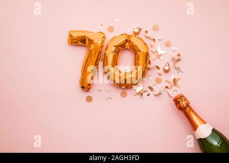 Felice settantesimo anniversario partito. Bottiglia di Champagne con numero gold palloncino. Foto Stock