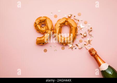 Felice novantesimo anniversario partito. Bottiglia di Champagne con numero gold palloncino. Foto Stock