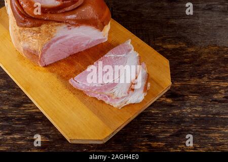 Affumicato tagliato il prosciutto di spalla di maiale sul tagliere Foto Stock