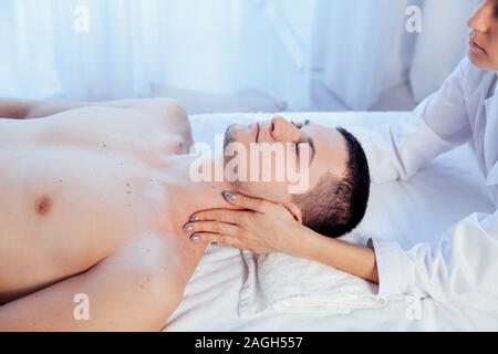 Medico cosmetologo facendo il massaggio del viso uomini trattamenti termali Foto Stock