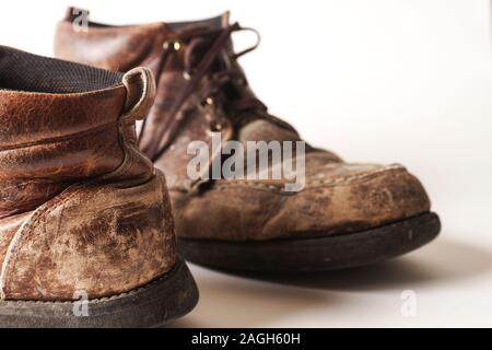 Fotografia di uomo di Dirty old stivali in pelle su sfondo bianco Foto Stock