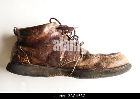 Fotografia di uomo di Dirty old stivali in pelle su sfondo bianco Foto Stock