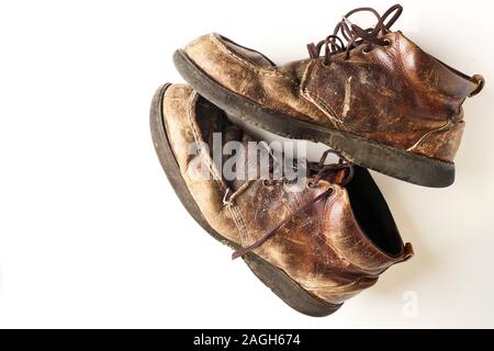 Fotografia di uomo di Dirty old stivali in pelle su sfondo bianco Foto Stock