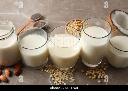 Occhiali con diversi tipi di latte sulla sfondo marrone, spazio nemico del testo. Primo piano Foto Stock