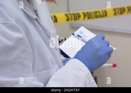 I tecnici forensi prendendo campioni di DNA da sangue la macchia con un batuffolo di cotone su omicidio scena del crimine. Esperto di criminologia di raccolta delle prove il crimine Foto Stock