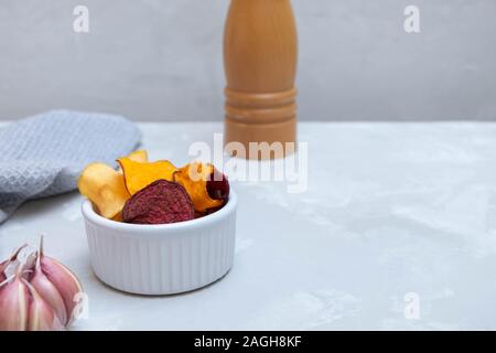 Sana chip vegetariano fatto da barbabietole, carote, patate dolci, pastinaca su folle tabella di calcestruzzo Foto Stock