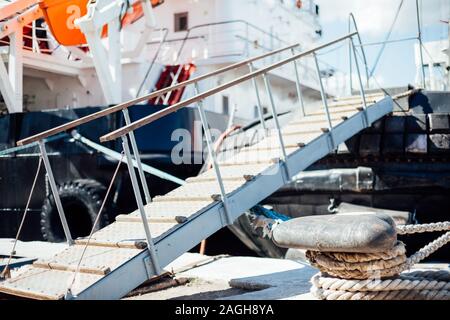 La nave è ormeggiata in un dock scaletta catena corda Foto Stock