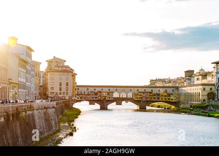 Il famoso ponte di Firenze sul fiume Arno in raggi del tramonto. Bella città italiana sul lungofiume. Viaggiare in Italia Foto Stock