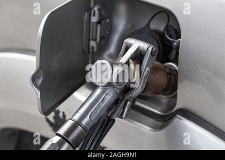 Riempimento GPL di SUV auto in una stazione di benzina, vicino la foto della pistola di rifornimento Foto Stock