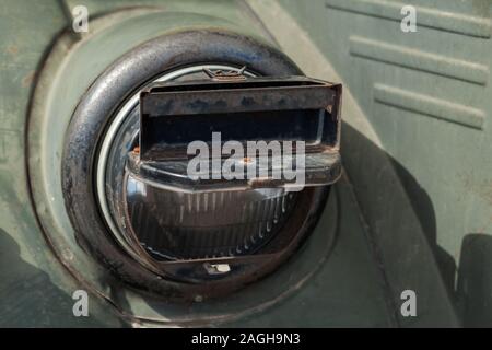 Faro rotondo di una vettura militare con il blackout coperchio fari su di esso, old-timer veicolo dal periodo della seconda guerra mondiale. Close up foto Foto Stock