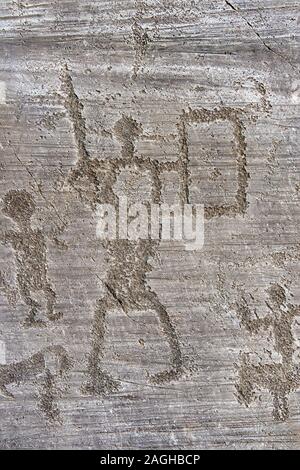 Petroglyph, rock carving, di un guerriero schematica tenendo uno scudo e spada. Scavate da antichi Camuni persone in età del ferro. Foto Stock