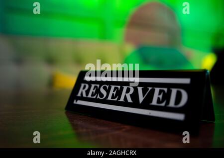 Riservati sign in piedi sul tavolo di legno in bar Foto Stock