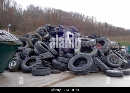 Pila di auto usate di pneumatici in un deposito di rifiuti in attesa di riciclaggio o distruzione. Foto Stock