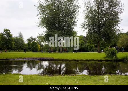 Vista di persone appendere fuori, alberi, campo di erba, stagno sul Vondelpark di Amsterdam. Si tratta di un pubblico parco urbano di 47 ettari. Si tratta di un giorno d'estate. Foto Stock