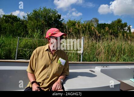 L'uomo sul viaggio in barca lungo Wicken Lode, Wicken Fen Riserva Naturale, Wicken, Cambridgeshire, Regno Unito Foto Stock