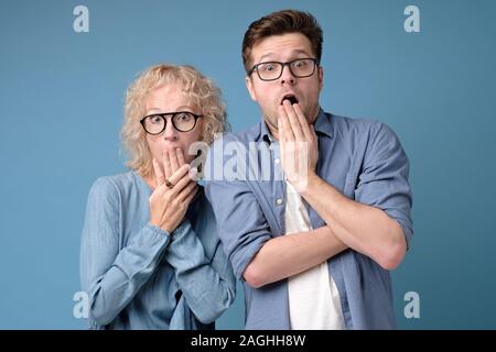 Donna e uomo in bicchieri hanno sconvolto espressioni, stand a stretto contatto tra loro Foto Stock