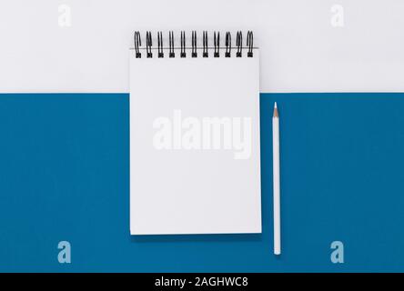 Aprire il blocco note e matita su un blu e sfondo bianco, con spazio di copia Foto Stock