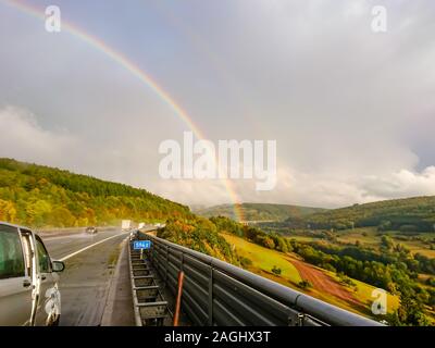 Un doppio arcobaleno dopo una pioggia pesante sull'autostrada Foto Stock