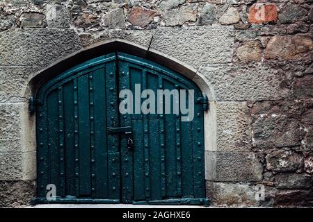 Una grande porta nel vecchio muro di pietra Foto Stock