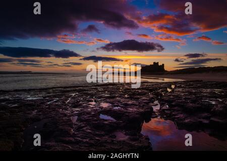 Sunrise su uno dei più iconica di inglese castelli, Bamburgh Castle il sito dell'antica capitale di Northumbria Foto Stock