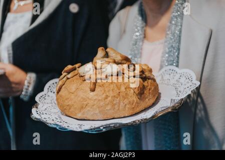 Tradizionale polacco saluto la sposa e lo sposo dai genitori con il pane e il sale. La vodka anche in bicchieri. Foto Stock