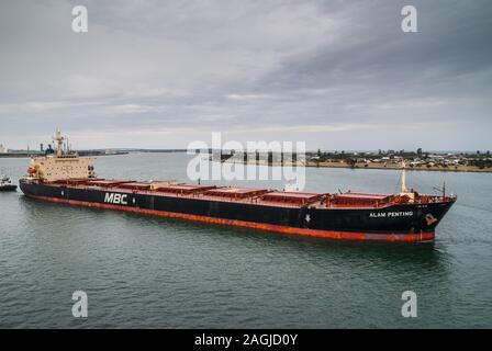 Newcastle, Australia - 10 dicembre 2009: il rosso e il nero Alam Penting Malaysia portarinfuse registrati a Singapore di lasciare il porto sul fiume Hunter und Foto Stock