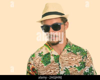 Studio shot di giovani bello uomo turistica indossando occhiali da sole isolata contro uno sfondo bianco Foto Stock