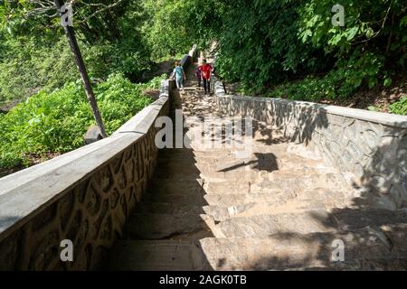 Dambulla, Sri Lanka - Novembre 19, 2019: i turisti a piedi giù per le ripide scale che portano indietro dal Dambulla tempio nella grotta Foto Stock