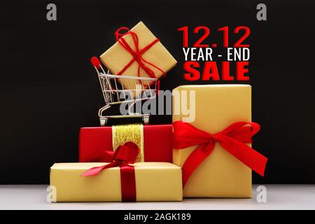12.12 a fine anno il concetto di vendita, carrello e confezione regalo su sfondo nero Foto Stock