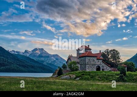 Il castello crap da Sass si trova in riva al lago di Silvaplana, Lej da Silvaplana, una alta altitudine lago vicino a San Moritz, montagne engadinesi a distanza Foto Stock