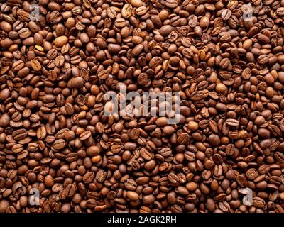Close-up di caffè tostato fagioli marrone sfondo, vista dall'alto, spazio di copia Foto Stock