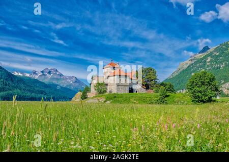 Il castello crap da Sass si trova in riva al lago di Silvaplana, Lej da Silvaplana, una alta altitudine lago vicino a San Moritz, montagne engadinesi a distanza Foto Stock