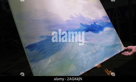 Artista copista paint seascape con nave in oceano. Artigiano arredatore disegnare come barca vela sul mare blu con olio acrilico colore. Disegnare la spazzola, coltello tavolozza. Foto Stock