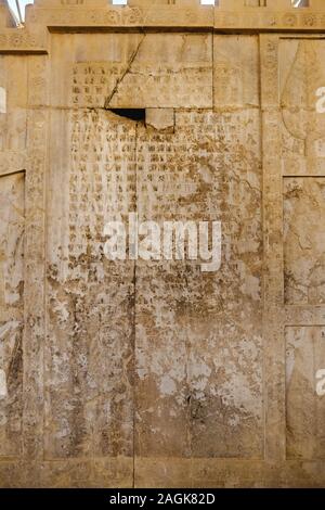 Rovine antiche vecchie scrittura cuneiforme persiana stone iscrizione ai corsi di lingua sumera a Apadana scale in antica dimora storica Persepolis, Iran. Foto Stock