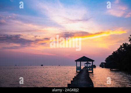 Bellissima vista del tramonto al villaggio di pescatori di mattina al mare. con padiglione in legno Foto Stock