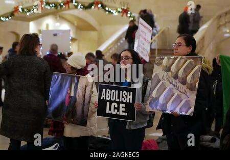 New York, NY / STATI UNITI D'America - 19 dicembre 2019: Tre militanti dal gruppo di salita e di resistere a NYC tenere indicazioni durante una silenziosa protesta contro il continuo Foto Stock